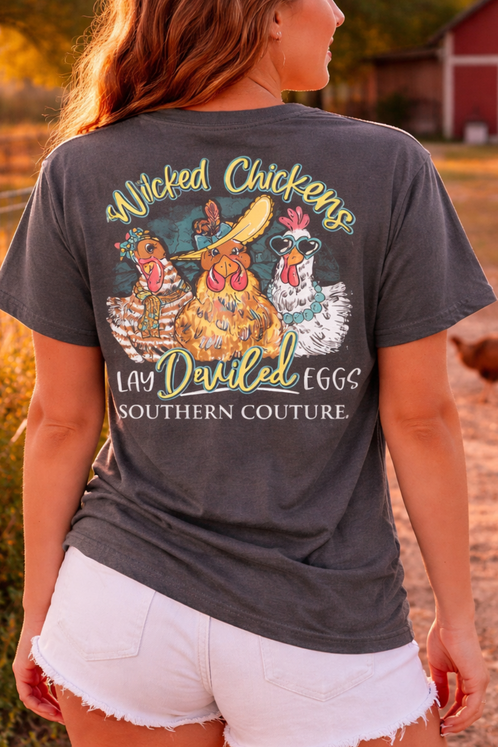 Woman wearing a t-shirt with a chicken graphic and text in an outdoor setting.