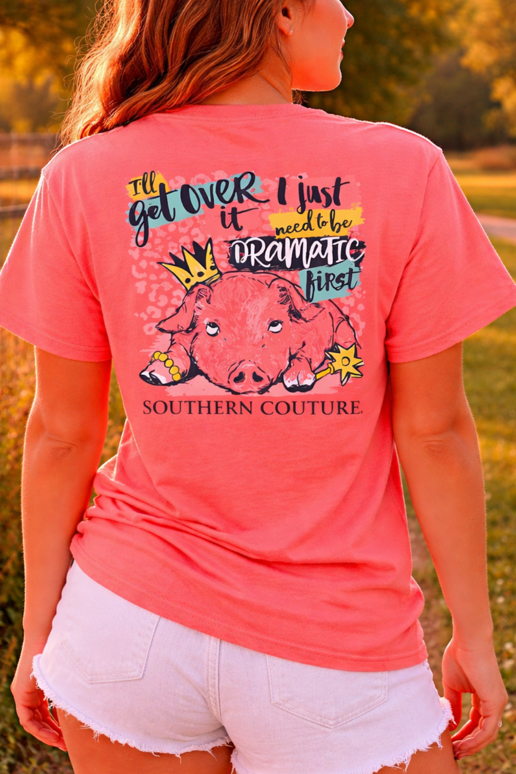 Woman wearing a pink t-shirt with a graphic design in a park setting
